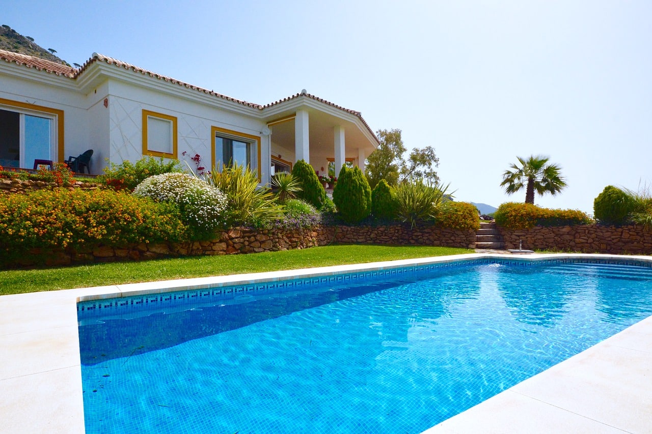 extérieur d'une maison avec une piscine et des arbustes